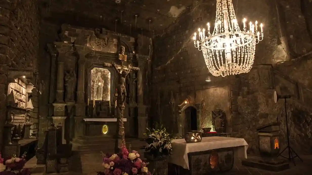 Dekoracyjny żyrandol wisi z sufitu pomieszczenia, oświetlając przestrzeń ciepłym światłem.